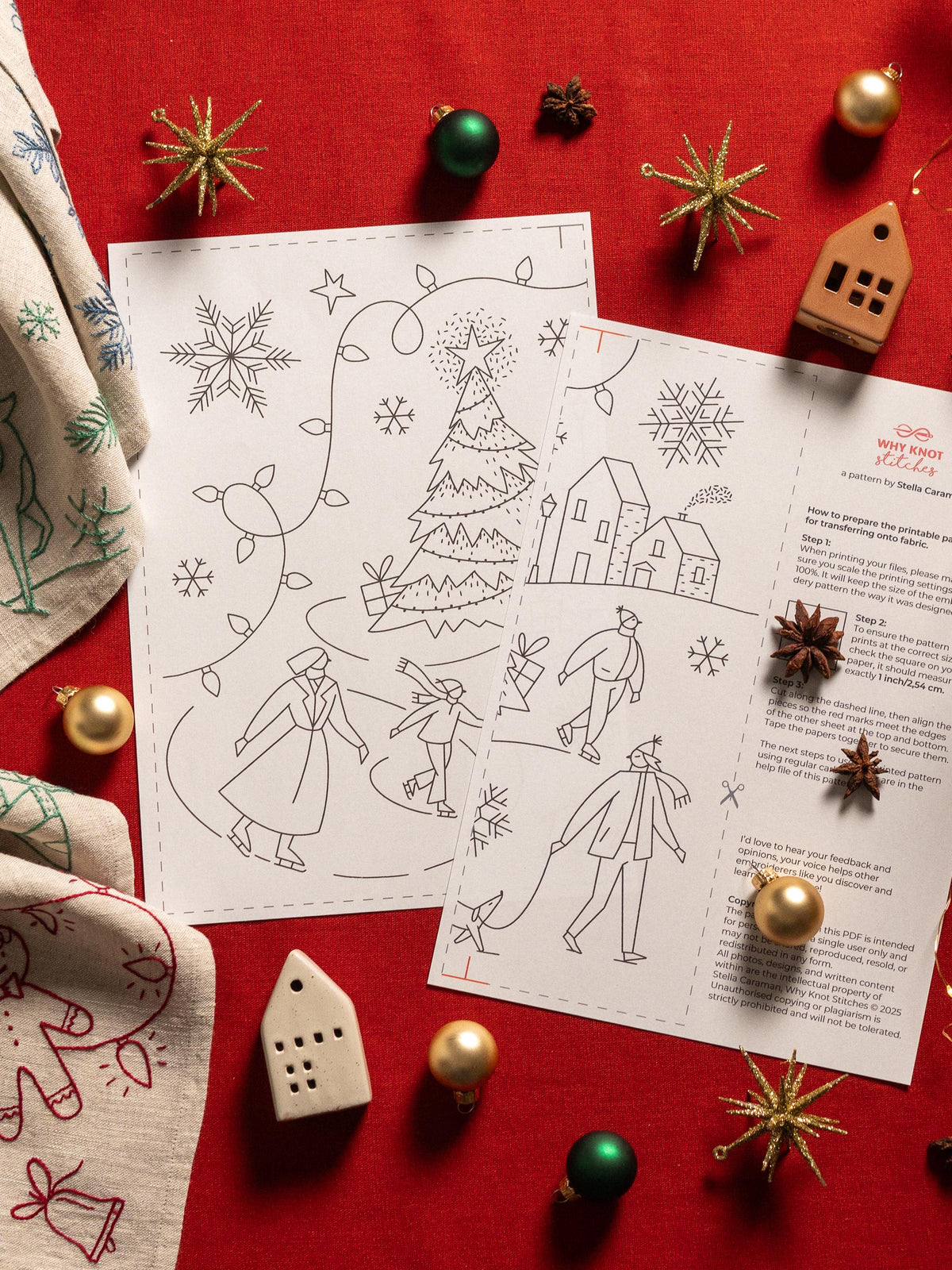 May include: Two black and white Christmas-themed embroidery patterns with illustrations of a Christmas tree, houses, and people ice skating. The patterns are surrounded by Christmas ornaments and decorations on a red surface.