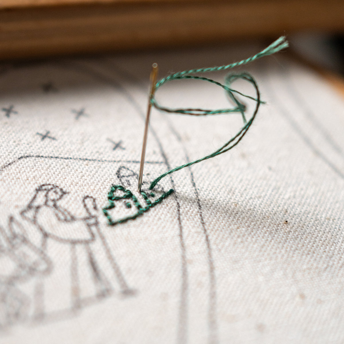 Hand-embroidered Christmas heart ornament featuring Mary riding a donkey alongside Joseph on the road to Bethlehem, with golden stars and a softly lit festive background.